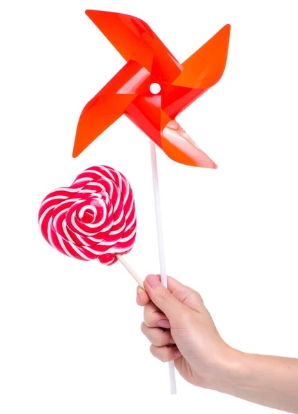Candy and toy windmill in hand — Stock Photo, Image