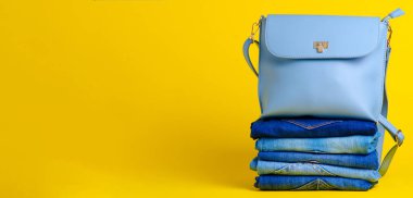 Katlanmış kot pantolon ve mavi moda kadın çantası.