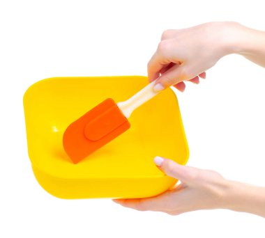 Elinde spatula olan plastik kase.