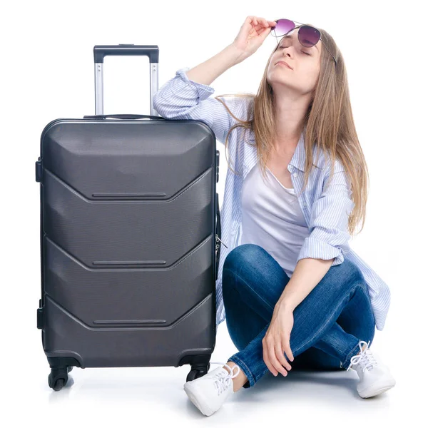 Woman with travel suitcase, sunglasses sitting waiting on white background isolation — Stock Photo, Image