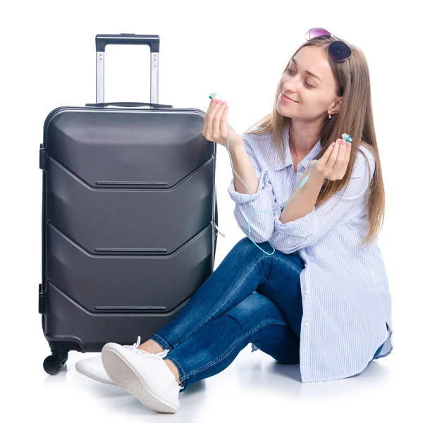 旅のスーツケースを着た女性、ヘッドフォンスマートフォンで音楽を聴いて座ってサングラス — ストック写真
