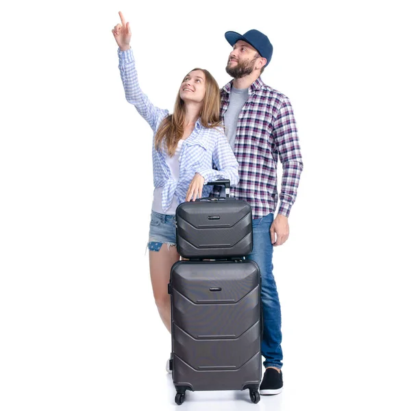 Szczęśliwa para turystów z czarnymi walizkami z uśmiechem pokazującym wskazujące — Zdjęcie stockowe