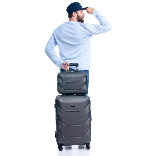 Чоловік в джинсах з дорожньою валізою стоїть — стокове фото