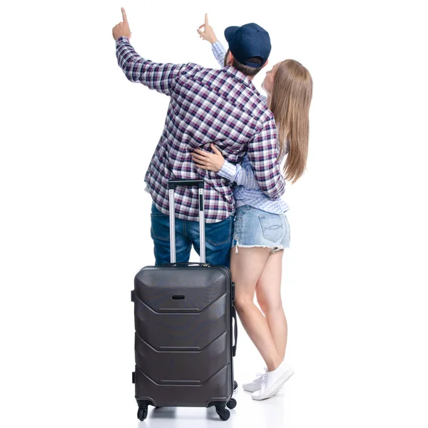 Szczęśliwa para turystów z czarnymi walizkami z uśmiechem na stojąco patrząc wskazując — Zdjęcie stockowe