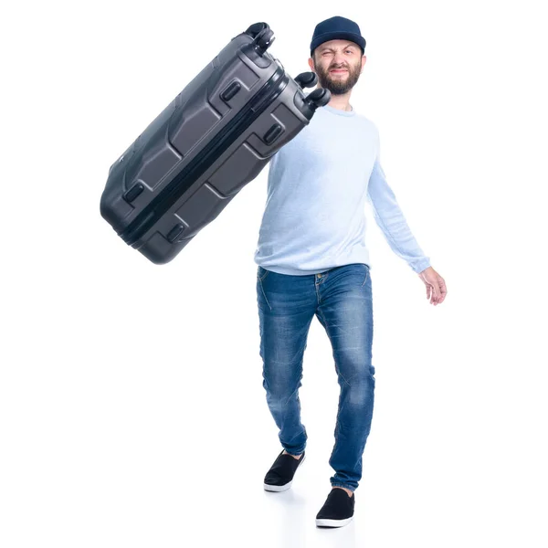 Чоловік в джинсах тримає кидає валізу, що стоїть — стокове фото