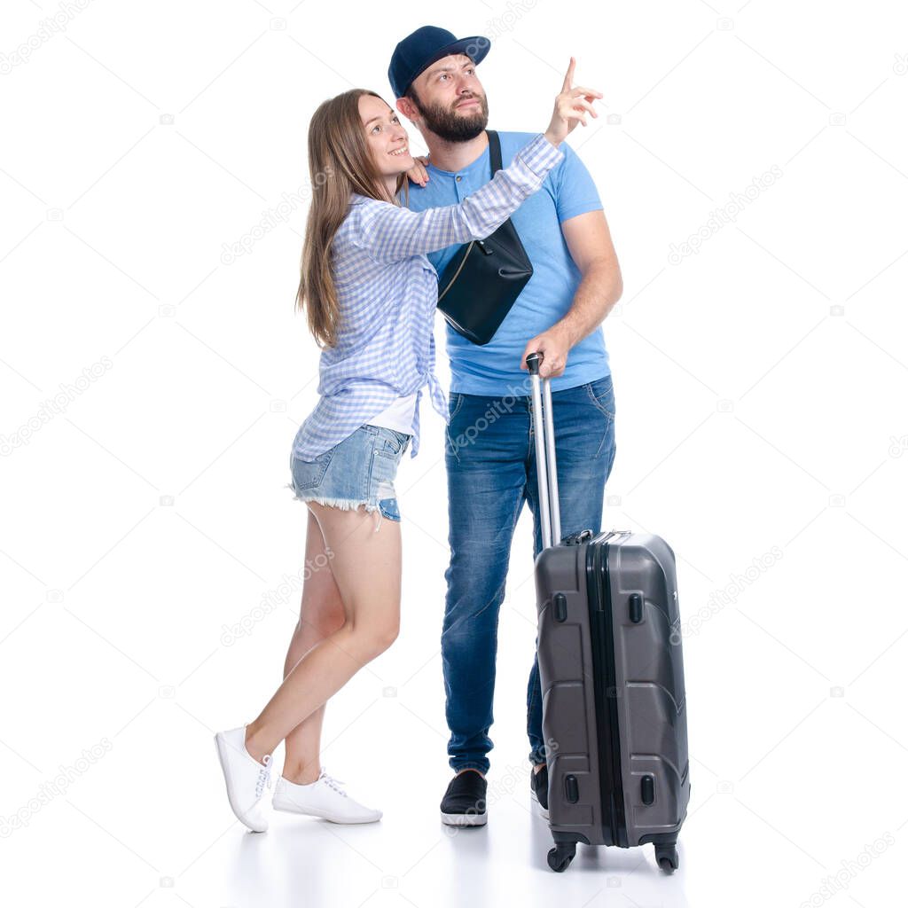 happy couple of tourists with black suitcase luggages smiling showing pointing