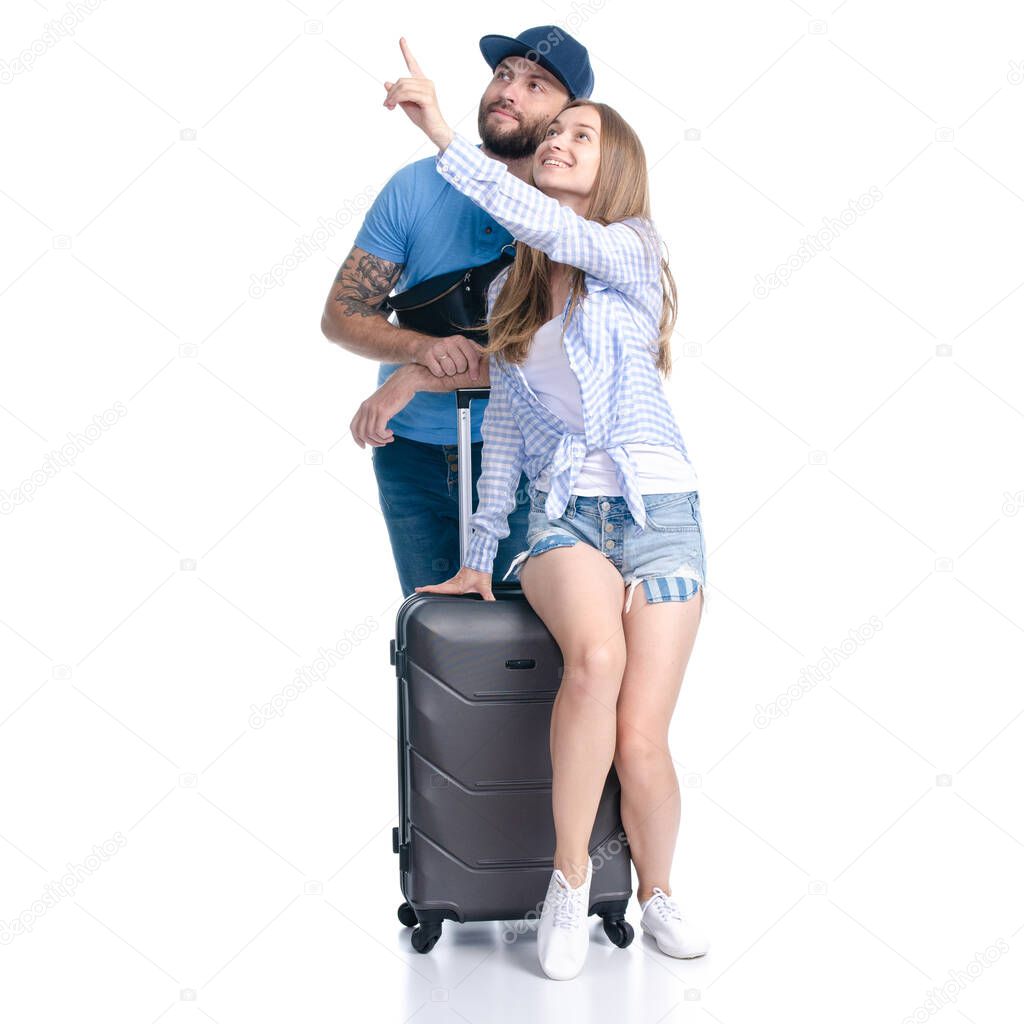 happy couple of tourists with black suitcase luggages smiling showing pointing