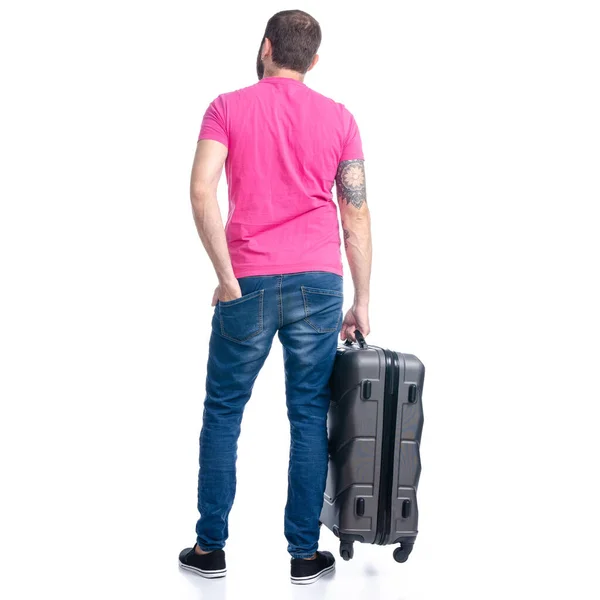 Uomo in jeans che tiene in piedi la valigia da viaggio — Foto Stock