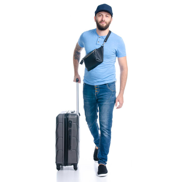 Man in jeans with travel suitcase goes walking