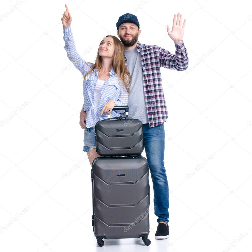 happy couple of tourists with black suitcase luggages smiling waving hands