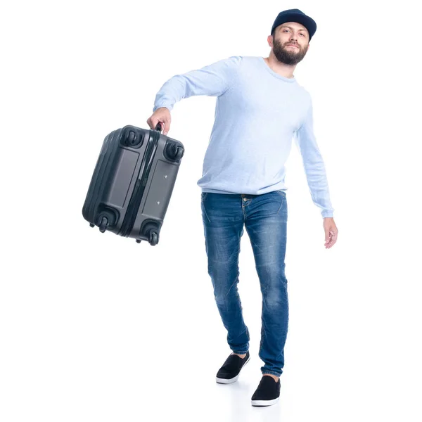 Чоловік в джинсах тримає кидає валізу, що стоїть — стокове фото
