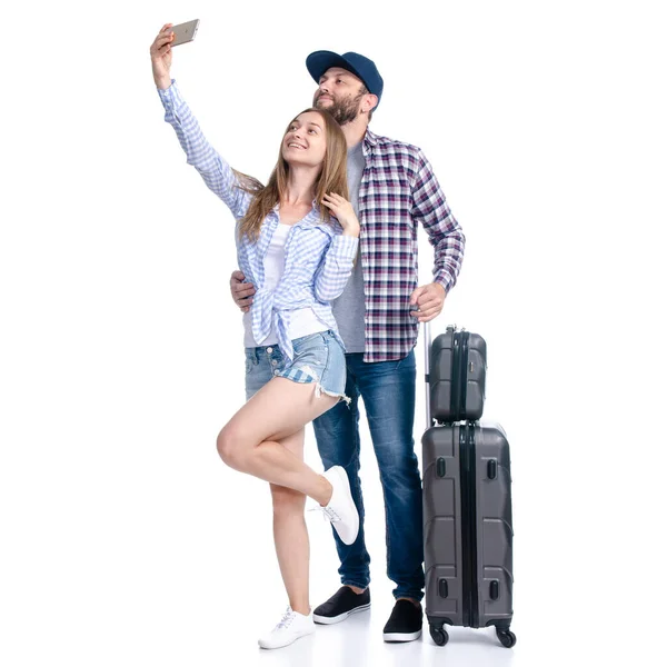 Feliz casal de turistas com malas pretas luggages sorrindo fazendo selfie no smartphone — Fotografia de Stock