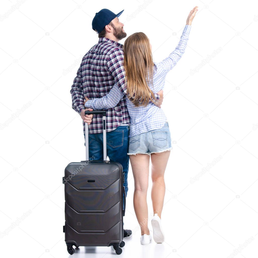 happy couple of tourists with black suitcase luggages smiling standing looking showing pointing