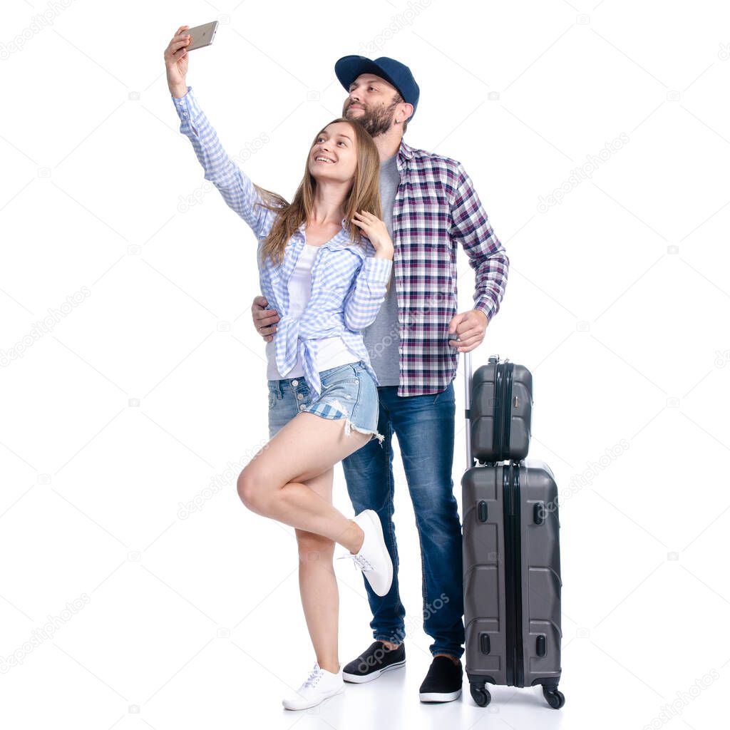happy couple of tourists with black suitcase luggages smiling making selfie on smartphone