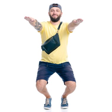 Şortlu ve şapkalı adam gülümsüyor.