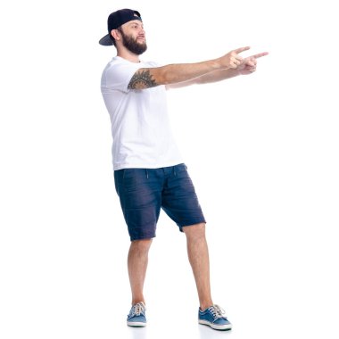 Şortlu ve şapkalı adam işaret ediyor.