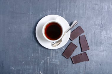 Beyaz çay fincanı. Gri, siyah, masa arkası çikolatalı.