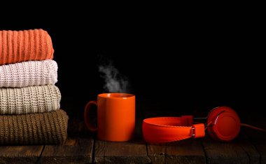 Bir fincan çay, kahve ve kulaklıkla örülmüş bir sürü kıyafet.