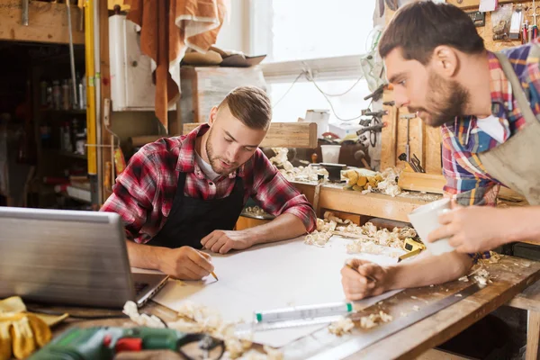 Carpinteros con portátil y plano en el taller — Foto de Stock
