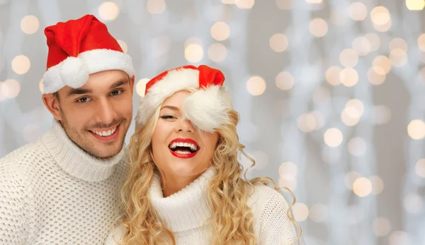 Glückliches Familienpaar in Pullovern und Weihnachtsmützen — Stockfoto