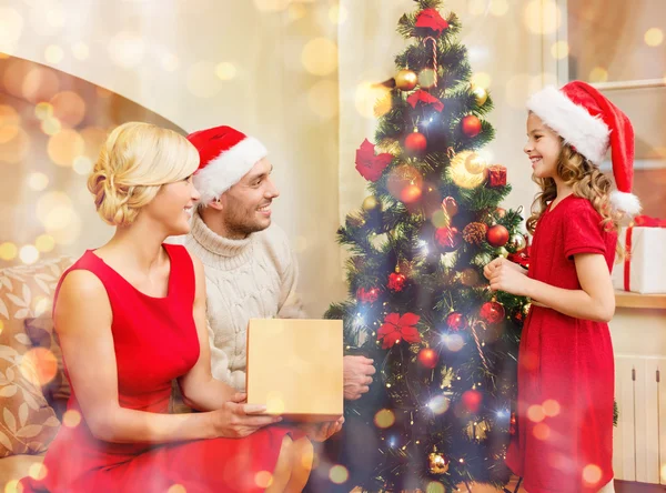 Smiling family decorating christmas tree — Stock Photo, Image