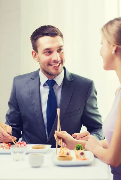 Pareja sonriente comiendo sushi en el restaurante —  Fotos de Stock