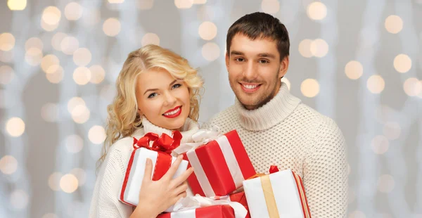Casal feliz em camisolas segurando presentes de Natal — Fotografia de Stock