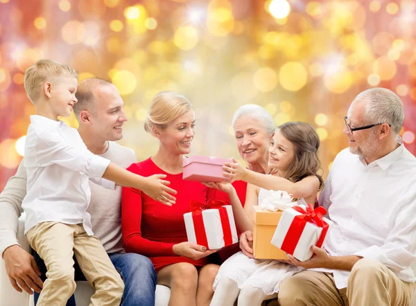 Glückliche Familie mit Weihnachtsgeschenken über Lichtern — Stockfoto