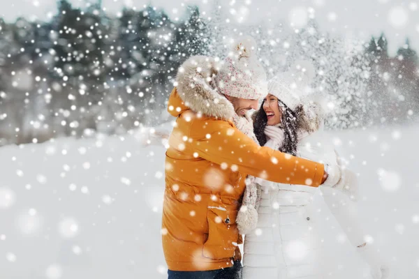 Gelukkige paar knuffelen en lachen in de winter — Stockfoto