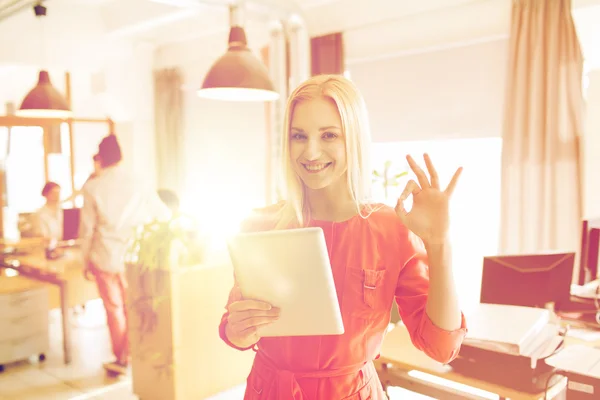 Femme avec tablette pc montrant ok signe au bureau — Photo