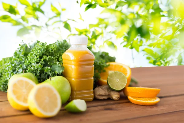 Пляшка з апельсиновим соком, фруктами та овочами — стокове фото