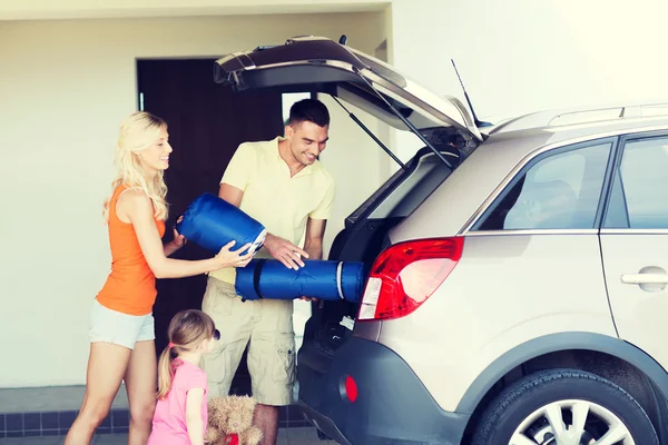 Szczęśliwa rodzina pakowania rzeczy do samochodu w domu parking — Zdjęcie stockowe