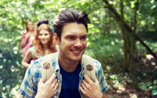 Groep lachende vrienden met rugzakken wandelen — Stockfoto