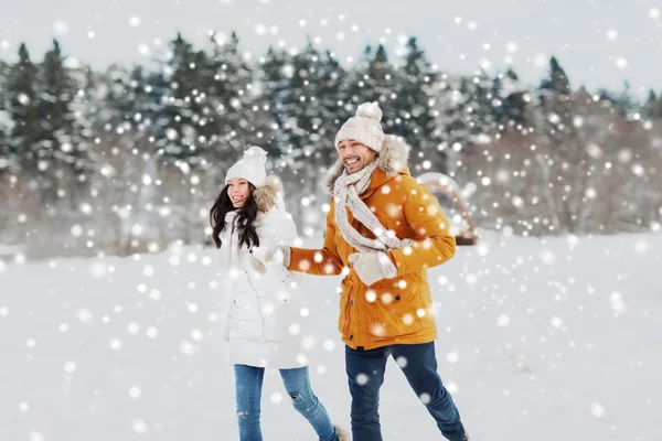 Gelukkige paar loopt over de achtergrond van de winter — Stockfoto