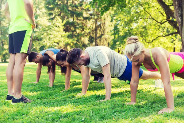 Grupo de amigos o deportistas que hacen ejercicio al aire libre — Foto de Stock