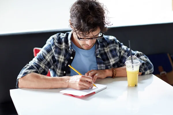 Homme avec cahier et jus écrit au café — Photo