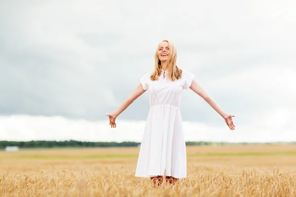 Giovane donna sorridente in abito bianco sul campo di cereali — Foto Stock