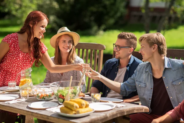 Happy přátelé na večeři na letní zahradní slavnost — Stock fotografie