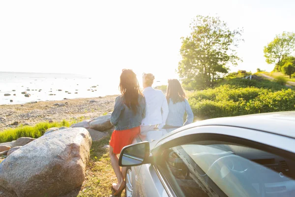 Щасливі дівчата-підлітки або жінки біля машини на морі — стокове фото