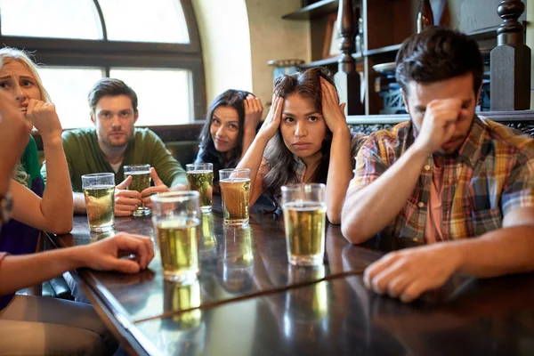 Friends with beer watching football at bar or pub — Stock Photo, Image