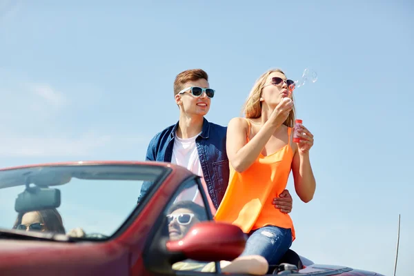Venner som kjører bil og blåser bobler – stockfoto