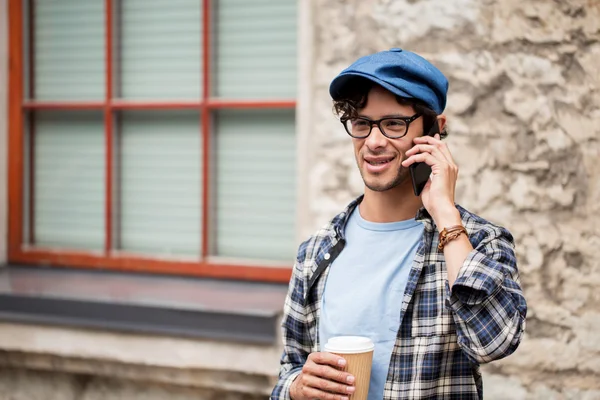 Hombre con café llamando en el teléfono inteligente en la ciudad — Foto de Stock