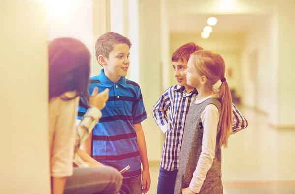 Grupo de niños sonrientes de la escuela hablando en el pasillo Imagen De Stock