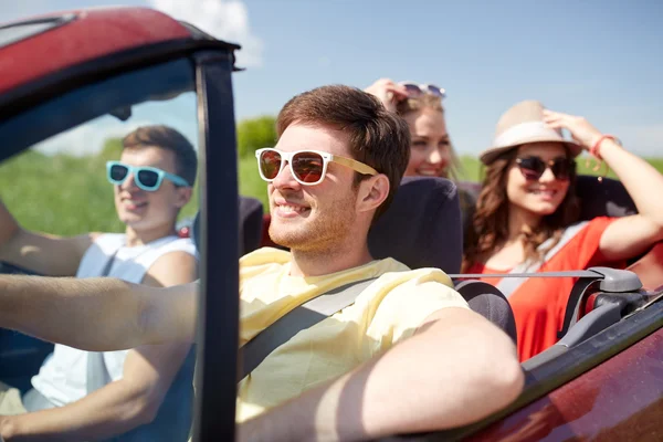 Amigos felizes dirigindo em carro cabriolet — Fotografia de Stock