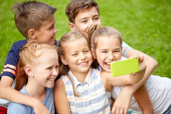 Glada barn eller vänner tar selfie i sommaren park — Stockfoto