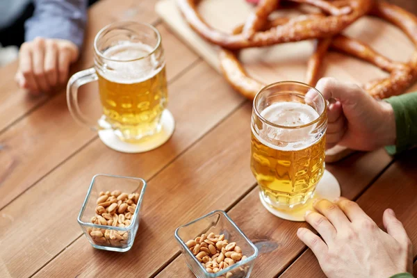 Primer plano de las manos con tazas de cerveza en el bar o pub — Foto de Stock