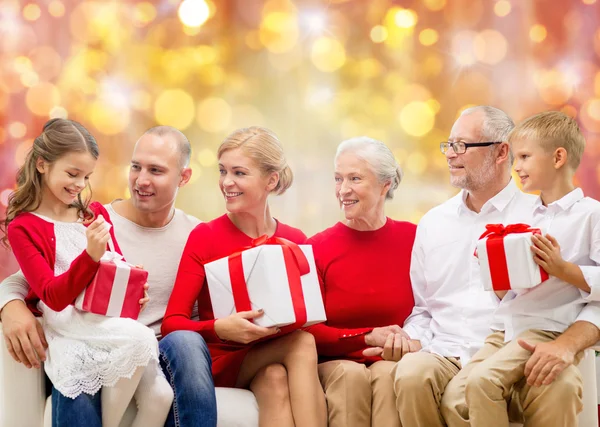 Happy family with christmas gifts over lights — Stock Photo, Image