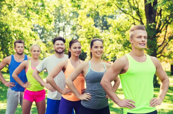 Grupp med glada vänner eller idrottsmän utomhus — Stockfoto