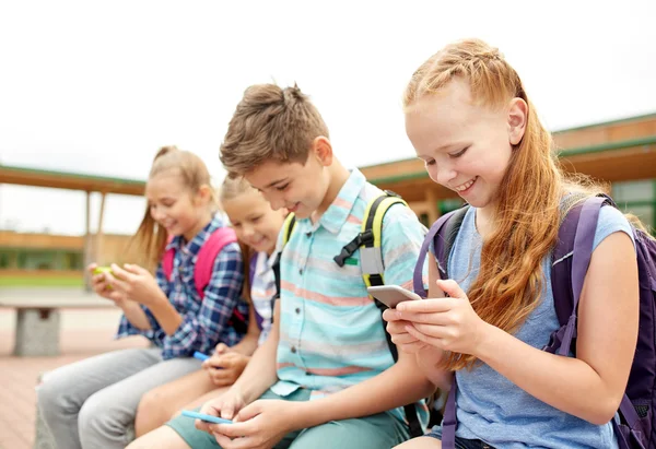 Alunos do ensino fundamental com smartphones — Fotografia de Stock