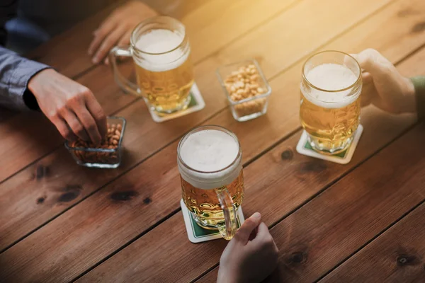 Close-up van handen met bierpullen op bar of pub — Stockfoto
